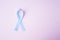 Prostate cancer awareness blue ribbon on pink background.