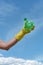 Protect our environment. Vertical shot of a volunteer wearing yellow rubbish glove holding used plastic bottle against