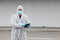 Protected worker wearing cloth, mask and gloves using tablet, corona virus protection