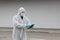 Protected worker wearing glasses, mask and gloves using tablet, corona virus protection