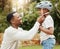 Protecting his baby. a father adjusting his sons helmet outside.