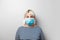 Protection against virus, SARS, coronavirus epidemic. Adult woman in a striped sweater and medical mask on a background