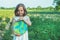 Protection and love of earth. Little girl holding planet in hands against green spring background. Earth day holiday concept.