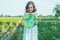 Protection and love of earth. Little girl holding planet in hands against green spring background. Earth day holiday concept.