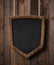 Protection shield shaped blackboard hanging on ropes and wood planks background