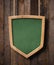 Protection shield shaped green blackboard hanging on ropes and wood planks background