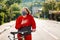 Protection from the virus. Portrait of a woman in a protective medical mask and sportswear, holding a Bicycle, and clutching her