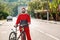 Protection from the virus. Portrait of a woman in a protective medical mask and sportswear, posing with a Bicycle on an empty road