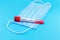 Protective face mask or medical mask with coronavirus tube test on blue background. Coronavirus or COVID-19 protection concept