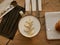 Protective facial mask with cookies, croissant, cutlery and a cup of coffee on a wooden table in the cafe.