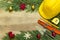 Protective helmet, mason tools and Christmas decorations on wooden background