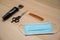 Protective mask, scissors, hair and beard clipper with attachments on the wooden work table of the hairdresser. Barbershop