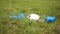 Protective medical mask and gloves lie on the grass. A teenager picks up trash from the grass. Epidemic of coronovirus