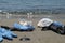 Protective virus mask and plastic gloves garbage trash on sandy sea shore,coronavirus covid pollution disease