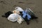 Protective virus mask and plastic gloves medical waste on sandy sea coast,coronavirus covid pollution disease