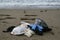 Protective virus mask and plastic gloves medical waste on sandy sea shore,coronavirus covid pollution disease
