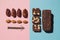 Protein date fruit candy bars fitness with nuts and fruit almond and chia poppy seeds top view on blue pink background