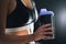 Protein shake after workout and gym training. Fit woman holding bottle of sport drink, whey or healthy smoothie.