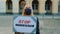 Protest walk: woman in protective mask protesting to stop aggression by holding steamer