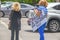 Protesting kids in cages - immigration issues -Two unidentifiable women protesters cross busy street - one carrying sign that says