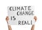 Protestor holding placard with text Climate Change Is Real on white background, closeup