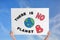 Protestor holding placard with text There Is No Planet B against blue sky, closeup. Climate strike