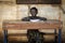 Proud African Schoolgirl Sitting In Her Desk Smiling school bac