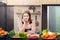 Proud attractive asian female cook standing in her home kitchen