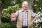 Proud content man holds a beetroot in the garden