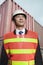 Proud engineer in protective workwear standing in a shipping yard