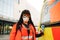 Proud female paramedic posing at ambulance vehicle near hospital