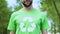 Proud male in green t-shirt with recycling symbol smiling on camera, ecology