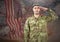 Proud soldier saluting against fluttering american flag and fireworks in background