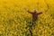 Proud successful oilseed rape farmer in blooming field