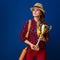 Proud woman hiker on blue background holding goblet