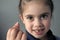 Proud young girl holds her first falling milk teeth