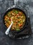 Provencal vegetables, sausage stew ragout in a frying pan on a dark background, top view