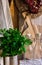 Provence rustic kitchen interior, wood cutting board, utensils, glass bottles, fresh herbs, linen towel on white background