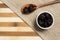 Prune inside brown ceramic and wooden spoon on bamboo wooden background