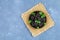 Prunes and fresh mint leaves in a bowl on a concrete table.