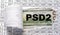 PSD2 - acronym behind torn paper with numbers on a white background with a magnifying glass