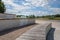 Pskov, summer promenade and benches in front of river and the Mirozhsky monastery