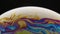 Psychedelic abstract planet from soap bubble on black background. Light refraction on a soap bubble, vacro close up
