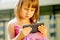 Psychological image of cute little girl addicted to likes. Close up nervous child with mobile smart phone. Emotional and socail