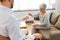 Psychologist giving glass of water to senior woman