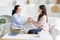 Psychotherapist and female patient uniting hands together due successful therapy