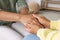 Psychotherapist holding patient`s hand in office, closeup