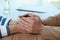 Psychotherapist holding patient`s hands at table indoors, closeup