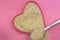 Psyllium in the shape of a heart on a pink background, top view. Super food psyllium seeds, keto diet ingredient