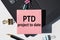 PTD - Project To Date acronym, note is written on a paper sticker on a laptop keyboard